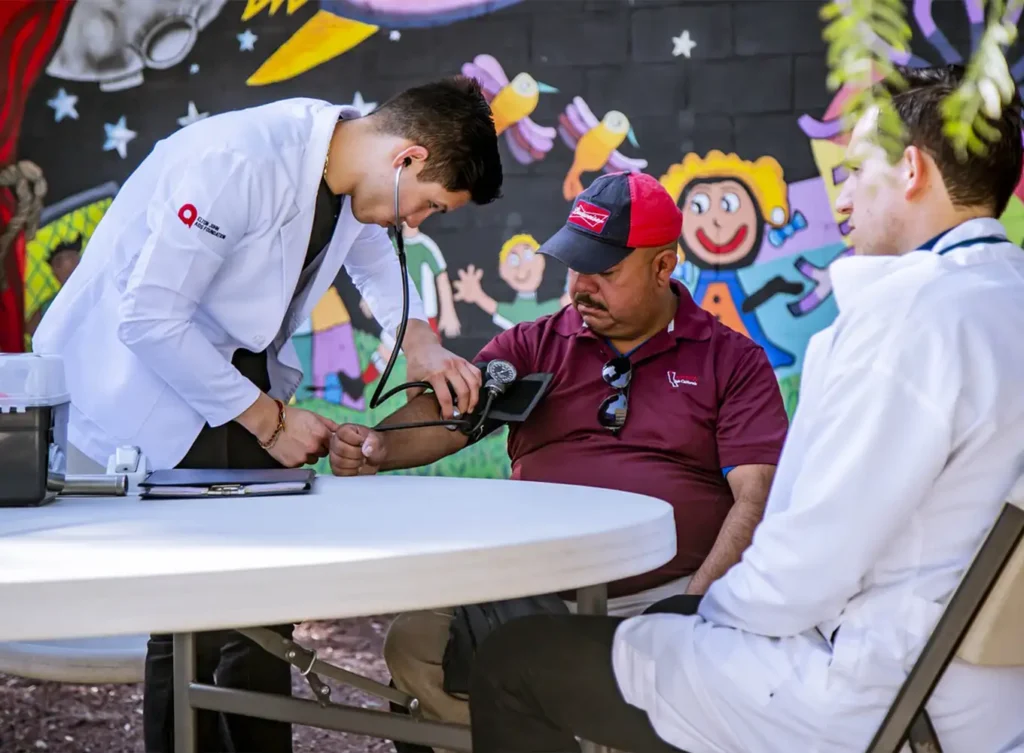 medical student taking a man's blood pressure